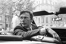 Roger-Viollet | 1376364 | Jean-Louis Trintignant (1930-2022), French actor and film director, in a cabriolet, on the boulevard Saint-Germain. Paris (VIth arrondissement), 1969. Photograph by André Perlstein (born in 1942). | © André Perlstein / Roger-Viollet