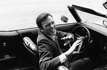 Roger-Viollet | 1376365 | Jean-Louis Trintignant (1930-2022), French actor and film director, in a cabriolet, on the boulevard Saint-Germain. Paris (VIth arrondissement), 1969. Photograph by André Perlstein (born in 1942). | © André Perlstein / Roger-Viollet
