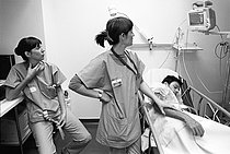 Roger-Viollet | 1395857 | Le service des urgences de l'Hôtel-Dieu. Paris (IVème arr.), 1992. Deux infirmières veillent sur un patient. Photographie de Jean-Louis Courtinat. | © Jean-Louis Courtinat / Roger-Viollet