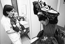 Roger-Viollet | 1395863 | Le service des urgences de l'Hôtel-Dieu. Paris (IVème arr.), 1999. Une femme vivant seule avec son enfant est accueillie par l'infirmière. Photographie de Jean-Louis Courtinat. | © Jean-Louis Courtinat / Roger-Viollet