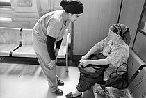 Roger-Viollet | 1395865 | Le service des urgences de l'Hôtel-Dieu. Paris (IVème arr.), 1999. Une infirmière discute avec une femme dans la salle d'attente des urgences. Photographie de Jean-Louis Courtinat. | © Jean-Louis Courtinat / Roger-Viollet